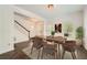 Open-concept dining area with modern wood table, chairs, and herringbone floors at 632 Warren Ave, Scottdale, GA 30079