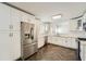 Spacious kitchen with stainless steel refrigerator, white cabinetry, quartz countertops, and herringbone patterned floors at 632 Warren Ave, Scottdale, GA 30079