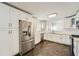 Modern kitchen with stainless steel fridge, ample white cabinetry, and beautiful dark hardwood floors at 632 Warren Ave, Scottdale, GA 30079