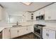 Modern white kitchen with stainless steel appliances, quartz countertops, subway tile, and herringbone floors at 632 Warren Ave, Scottdale, GA 30079