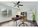 Office with wood floors, ceiling fan, two large windows, modern desk and book case at 632 Warren Ave, Scottdale, GA 30079