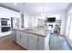 Bright, open-concept kitchen with a large island, stainless steel appliances, and seamless flow to the living area at 125 Leveret Rd, Locust Grove, GA 30248