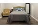 Cozy bedroom with hardwood floors, chair, mirror, and a comfortable bed with a decorative pillow at 2257 Rocksram Ct, Buford, GA 30519