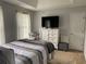 Bedroom featuring a queen-size bed, dresser with TV, and neutral decor at 2257 Rocksram Ct, Buford, GA 30519