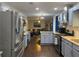 Modern kitchen seamlessly flowing into the living area, featuring stainless steel appliances and blue cabinets at 2257 Rocksram Ct, Buford, GA 30519