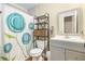 Modern bathroom with a decorative shower curtain, grey vanity, and organized storage shelves for essentials at 4326 Megan Manor Sw Dr, Powder Springs, GA 30127