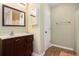 Bathroom with a wood vanity, a framed mirror, and a shower tub at 4326 Megan Manor Sw Dr, Powder Springs, GA 30127