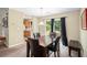 Inviting dining room with dark wood table, comfortable seating, and natural light from the sliding glass door at 4326 Megan Manor Sw Dr, Powder Springs, GA 30127