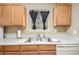 Bright kitchen featuring matching wooden cabinets, stainless steel sink, and a white dishwasher and counter tops at 4326 Megan Manor Sw Dr, Powder Springs, GA 30127