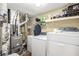 Functional laundry room with washer, dryer, and overhead shelving for storage at 4326 Megan Manor Sw Dr, Powder Springs, GA 30127