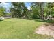 A vast grassy backyard featuring mature trees, a trampoline, and a play structure, perfect for outdoor activities at 5152 Clearwater Dr, Stone Mountain, GA 30087
