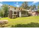 Backyard with an expansive lawn, brick exterior, screened porch, and a patio at 5152 Clearwater Dr, Stone Mountain, GA 30087