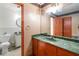 Bathroom featuring a green marble countertop, a large mirror, and toilet at 5152 Clearwater Dr, Stone Mountain, GA 30087