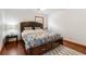 Comfortable bedroom features a dark wood bed frame, white walls, and wood flooring at 5152 Clearwater Dr, Stone Mountain, GA 30087