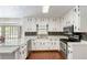 A bright kitchen with white cabinets, stainless steel appliances, and hardwood floors at 5152 Clearwater Dr, Stone Mountain, GA 30087