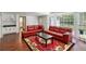 Bright living room with red leather furniture, a large rug, and natural light from bay windows at 5152 Clearwater Dr, Stone Mountain, GA 30087