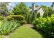 Picturesque backyard with artificial grass, mature trees, and decorative plantings at 1115 Third St, Stone Mountain, GA 30083