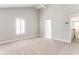 Large, sunlit bedroom featuring vaulted ceiling, neutral carpet, and plantation shutters at 1115 Third St, Stone Mountain, GA 30083
