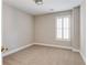 Bright bedroom featuring neutral carpeting, a window with bright shutters, and a ceiling light at 1115 Third St, Stone Mountain, GA 30083