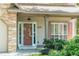 Charming front porch featuring a modern light fixture, brick accents and neatly trimmed bushes at 1115 Third St, Stone Mountain, GA 30083