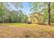 Spacious backyard with a yellow house, deck and mature trees, perfect for outdoor activities and relaxation at 115 Eagle Ridge Dr, Canton, GA 30114