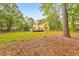 Lush backyard with mature trees surrounding a beautiful yellow house, providing a tranquil outdoor setting at 115 Eagle Ridge Dr, Canton, GA 30114