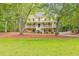 Charming yellow two-story home with a spacious front porch and well-manicured lawn surrounded by mature trees at 115 Eagle Ridge Dr, Canton, GA 30114