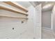 A functional laundry room with wooden shelving, white shiplap walls, and tile flooring at 115 Eagle Ridge Dr, Canton, GA 30114