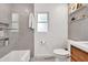 Modern bathroom features stylish gray tiles, a toilet, a bathtub, and a bright window at 2991 Windfield Cir, Tucker, GA 30084