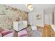 Charming Bedroom featuring stylish wallpaper, a white crib, and hardwood floors at 2991 Windfield Cir, Tucker, GA 30084