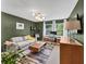 Modern living room featuring olive green walls, hardwood floors, and stylish furniture at 2991 Windfield Cir, Tucker, GA 30084