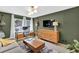 Modern living room with olive green walls, a gray couch, a wooden dresser and a desk at 2991 Windfield Cir, Tucker, GA 30084