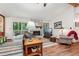 Cozy living room featuring a stone fireplace, wood floors, and sliding door to deck at 3679 Regent Nw Dr, Kennesaw, GA 30144