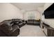 Spacious carpeted basement featuring dark leather couches and flat screen TV at 704 Fairlane Dr, Marietta, GA 30064