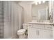 Clean bathroom features a white vanity, toilet, and a shower with a striped curtain offering a modern touch at 704 Fairlane Dr, Marietta, GA 30064