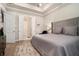 Primary bedroom featuring tray ceiling, plush area rug, king bed and ensuite bathroom at 704 Fairlane Dr, Marietta, GA 30064