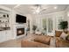 Bright living room with fireplace, hardwood floors, built-in shelving, and double doors to the backyard at 704 Fairlane Dr, Marietta, GA 30064