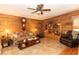 Cozy living room featuring wooden walls, tile flooring, ceiling fan and built-in shelving at 20 Mahan Ne Ln, Rydal, GA 30171