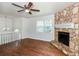 Inviting living room featuring a stone fireplace, a ceiling fan, and hardwood flooring at 2636 Suzanne Ln, Acworth, GA 30102