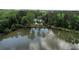 Picturesque aerial view of a lakeside home featuring lush greenery and a serene pond with a fountain at 3109 Country Lake Dr, Powder Springs, GA 30127