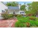 Beautifully landscaped backyard with a fountain as a focal point, surrounded by brick pathways and colorful flowers at 3109 Country Lake Dr, Powder Springs, GA 30127