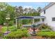 Well-maintained backyard showcasing a fountain and carport, surrounded by colorful flowers at 3109 Country Lake Dr, Powder Springs, GA 30127