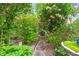 Lush backyard featuring a serene stone path winding through vibrant trees and foliage at 3109 Country Lake Dr, Powder Springs, GA 30127
