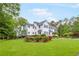 View of landscaped yard and home with many windows at 3109 Country Lake Dr, Powder Springs, GA 30127