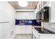 Compact kitchen featuring white appliances and cabinets with blue tile backsplash at 3109 Country Lake Dr, Powder Springs, GA 30127