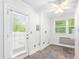 Bright laundry room with tiled floor, door to deck, utility connections, and a modern ceiling fan at 3109 Country Lake Dr, Powder Springs, GA 30127