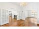 Open living room featuring hardwood floors, glass paneled doors, and elegant chandelier at 3109 Country Lake Dr, Powder Springs, GA 30127