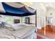 Large main bedroom featuring a four-poster bed, hardwood floors, and ensuite bathroom at 3109 Country Lake Dr, Powder Springs, GA 30127