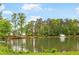Scenic view of the pond with a fountain and lush trees surrounding the property at 3109 Country Lake Dr, Powder Springs, GA 30127