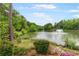 Picturesque view of a pond with a fountain, surrounded by lush greenery and trees at 3109 Country Lake Dr, Powder Springs, GA 30127